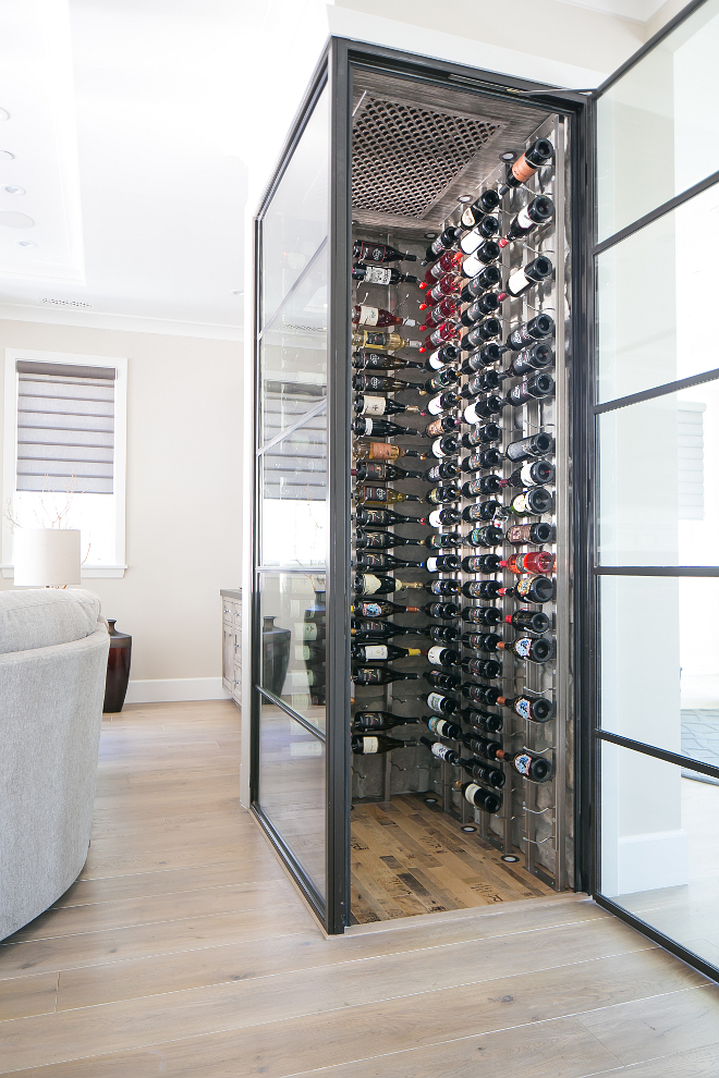 Forget the dark and dusty wine cellars we often find in basements. Today's wine cellars are all about displaying your beautiful wine collection. This glass enclosed climate controlled wine cellar keeps your wine handy while bringing some character to your home. Glass whine cellar. Living room glass wine cellar #glasswinecellar #winecellar Patterson Custom Homes. Brandon Architects, Inc.
