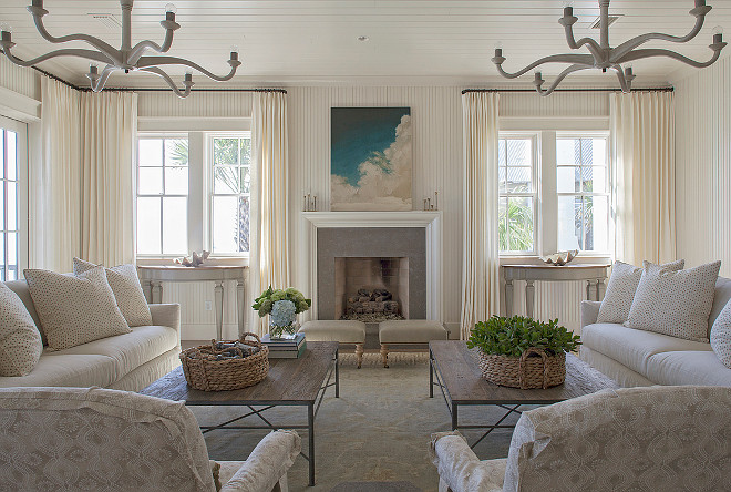 Ivory Living Room. Ivory coastal living room features an ivory beadboard ceiling accented with two light wood chandeliers illuminating a pair of ivory sofas facing each other across from a salvaged wood coffee table surrounded by French doors dressed in floor to ceiling ivory curtains. #LivingRoom #NeutralLivingroom #IvoryLivingroom #Ivoryinteriors #Neutralinteriors Urban Grace Interiors