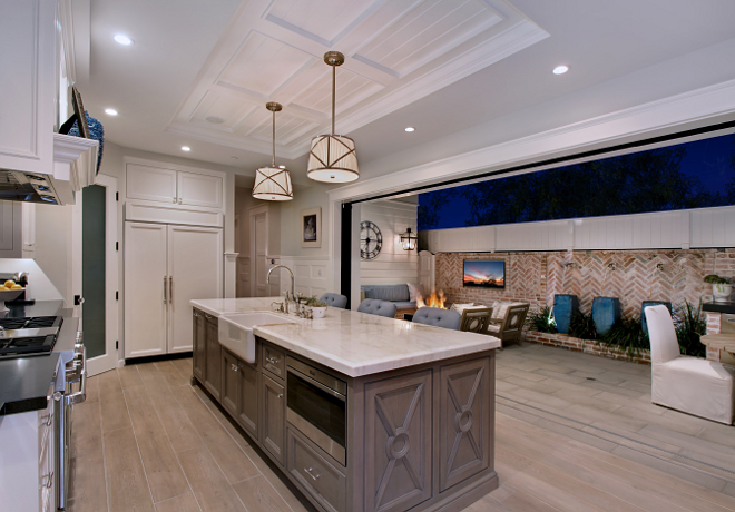Kitchen Island. The island features a built-in microwave. I love this view to the courtyard. Who wouldn't love to cook here? Notice the light color wood floor. #kitchen #kitchenisland Patterson Custom Homes. Interiors by Trish Steele, Churchill Design.
