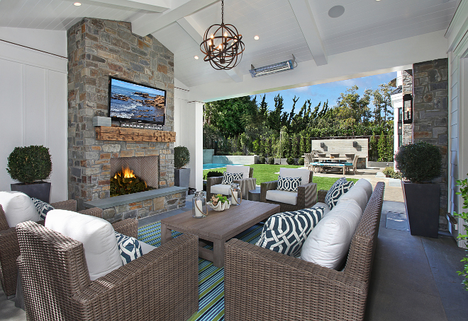 Covered Patio loggia ideas. What an inviting space! This loggia features a cozy seating area and board and batten walls flanking an outdoor fireplace. Notice the reclaimed wood mantle. #loggia #coveredpatio #outdoorfireplace Patterson Custom Homes. Interiors by Trish Steele of Churchill Design. 