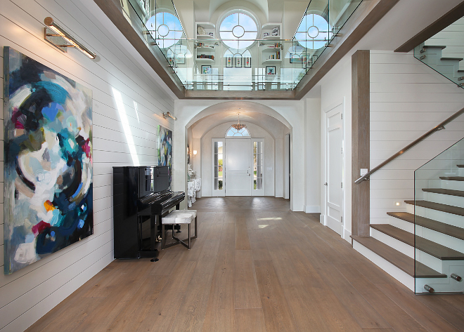Hall Ideas. Shiplap walls in hallway featuring custom art which incorporates the color palette used in the home. This is a fun spot for that upright black glossy piano. #Hall Interior white doors and trim paint color: "Behr's Whisper White". Patterson Custom Homes. Interiors by Trish Steele of Churchill Design. 