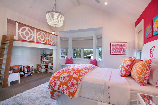 Kids Bedroom custom built-in loft. This bright pink and tangerine room has a seagrass feature wall, custom slipcover bed with large monogram in contrasting color. Beautiful loft bed inspired by owner with work space below. Built in window seat. All rooms feature woven black-out shades in pearl white. Patterson Custom Homes. Interiors by Trish Steele of Churchill Design. 