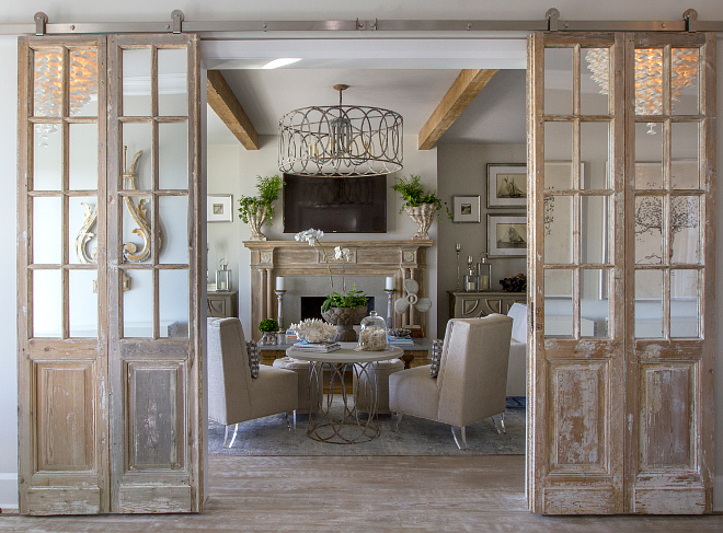 Antique doors as barn doors. Whitewashed antique doors on barn door hardware. Mirrored antique doors were hung in a barn door hardware in the formal living room to bring character and patina. The pale pine vintage mirror door set also features a whitewashed finish. #Antiquedoors #barndoor #BarndoorHardware #Whitewashedantiquedoor Heritage Homes of Jacksonville. Villa Decor & Design.