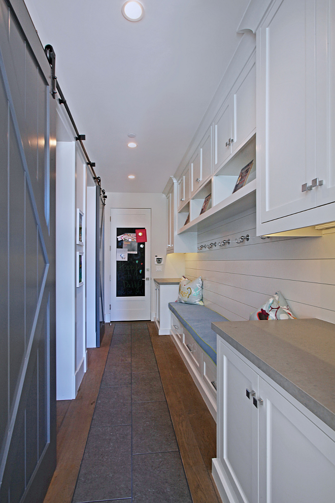 MudRoom. This long mudroom features lots of useful storage and custom cabinetry. Fabrics are by Kravet. Notice the matching barn doors for the pantry and second powder room. #mudroom #barndoor #cabinet Patterson Custom Homes. Interiors by Trish Steele of Churchill Design. 