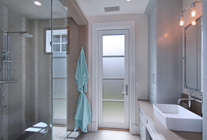 Bathroom. Guest bathroom featuring walk-in shower and paint by Benjamin Moore on cabinets and Barn door. Second door leads out to outdoor shower and gorgeous vegetable garden. #bathroom Patterson Custom Homes. Interiors by Trish Steele of Churchill Design. 