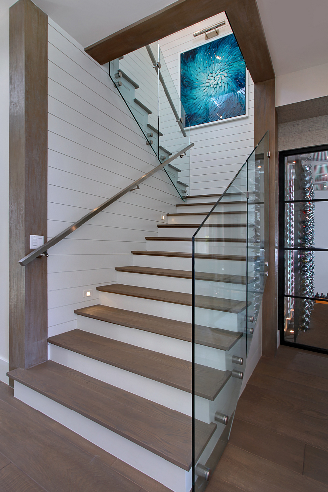 Staircase. Glass stair. This stunning staircase was designed by the architect and builder. The staircase features glass stair rail with steel hand rail and shiplap walls. #stair #glass #staircase Patterson Custom Homes. Interiors by Trish Steele of Churchill Design. 