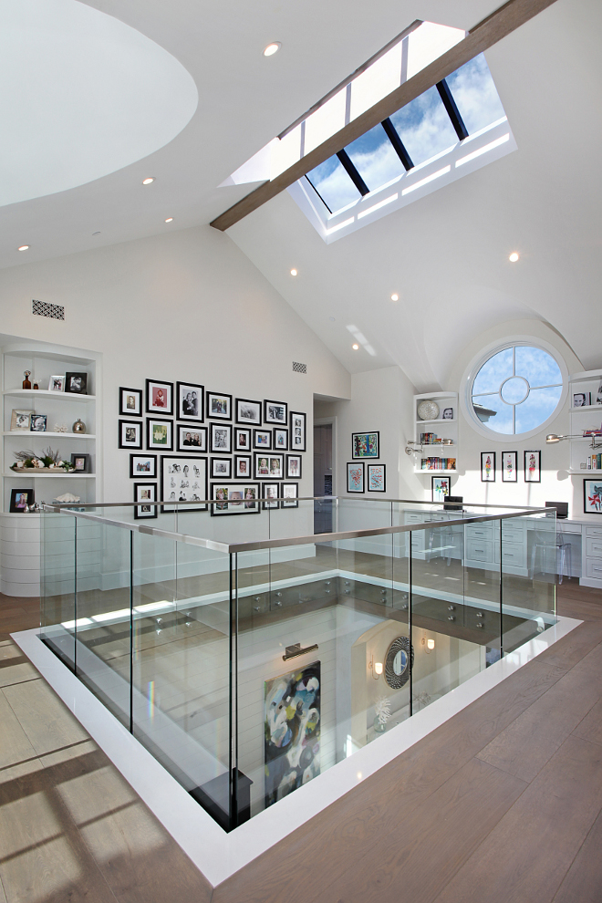 Upstairs Loft Glass Railing. The upstairs atrium features tons of light streaming through oversize round window and skylight. Patterson Custom Homes. Interiors by Trish Steele of Churchill Design. 