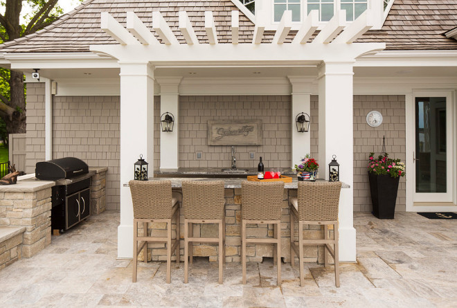 bar is complete with a barbecue, sink and refrigerator. The beautiful natural stone patio brings it all together. #outdoorkitchen #pergola #outdoors Southview Design