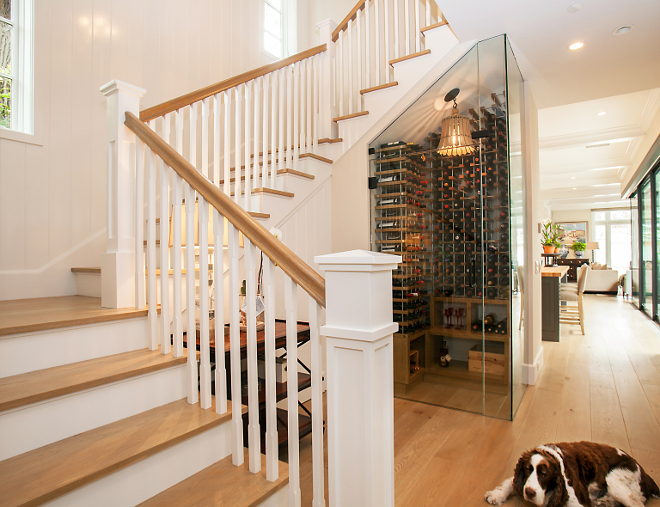 Glass wine enclosure. This all glass wine enclosure serves as a centerpiece to this gorgeous transitional home. The lighting fixture is Currey & Co.'s Frutier Pendant, made from natural ash and wrought iron. Patterson Custom Homes