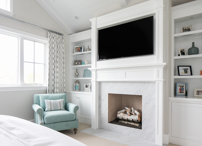 Bedroom fireplace. The master bedroom features a classic white marble fireplace surround with white bookshelves cabinetry on both sides. #bedroom #masterbedroom #fireplace #bookshelves #bookcase #cabinet Churchill Design 