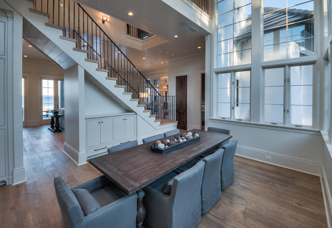 Dining room. Transitional dining room with floor to ceiling windows, plank wood floors and gray slipvovered dining chairs from Restoration Hardware. #Diningroom