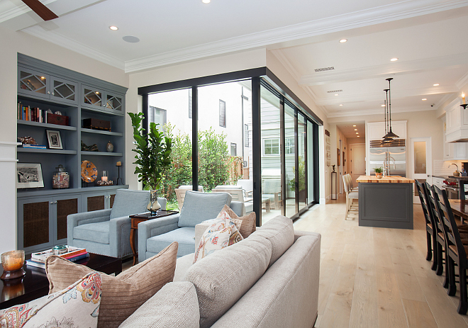 Great Room Design. Design Details: Floor: solid white oak with a custom stain applied after installation; Doors: Western Windows 7 Doors Sliders (108"H); Wall color: Benjamin Moore 971 Olympic Mountains; Built-In color: Benjamin Moore HC-162 Brewster Gray. Patterson Custom Homes