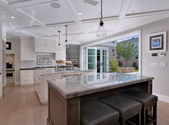 Kitchen with two islands and bifold doors to outdoors. One of the favorite features of the home is the open floor plan that flows into the yard and outdoor living space. Kitchen Island custom made from Rift Sawn White Oak with custom stain applied after installation. Kitchen Island Lighting: Restoration Hardware French Magnum 5L Pendant in Vintage Steel. Patterson Custom Homes