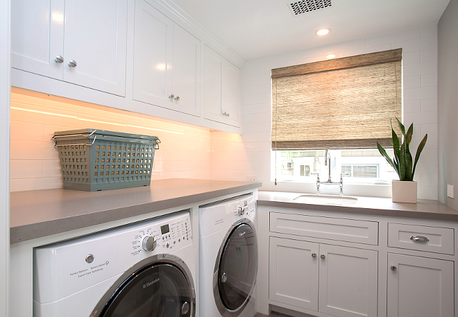 Laundry Room. Laundry with white cabinets and gray walls painted in Benjamin Moore 1599 Marina Gray. Laundry room features Sleek Concrete #4003 Quartz countertop and 4" x 16" white subway tile as backsplash. #BenjaminMoore1599MarinaGray #BenjaminMoore #1599 #MarinaGray #BenjaminMoorePaintcolors Patterson Custom Homes