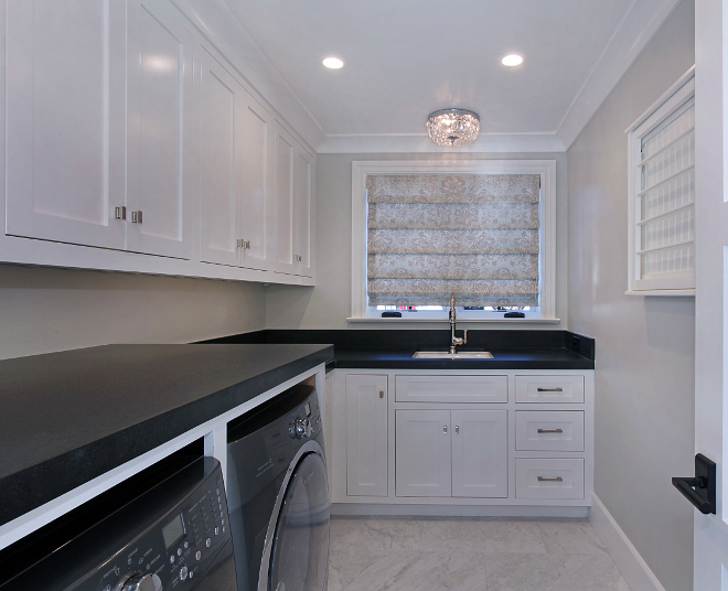Laundry Room. Gorgeous laundry room with white cabinets painted in "Dunn Edwards Whisper White" and gray walls painted in Dunn-Edwards Paints- Foil DE6360. Perimeter counters are Black Granite Scozzese. #laundryroom Patterson Custom Homes