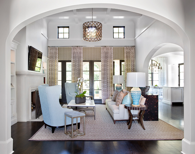 Living room. High ceiling, arches and tailored interiors are seen as soon you enter this home. In this living room, beautiful boxed beam ceilings and a limestone fireplace are sure to impress. #livingroom #boxedceiling #archway #arches #lighting #tailoredinteriors #interiors 