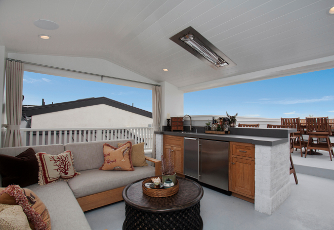 Roof Deck. This third floor roof deck loggia is the ultimate space to soak in the beach breeze! The teak wood faced cabinets with brick surround and neolith lava counter slab create a space perfect for entertaining. Details: Floor: Pacific Gray elastomeric deck coating; Counter: Neolith Lava; Hardware: Emtel Trail Pull & Knob. #RoofDeck #Deck Patterson Custom Homes