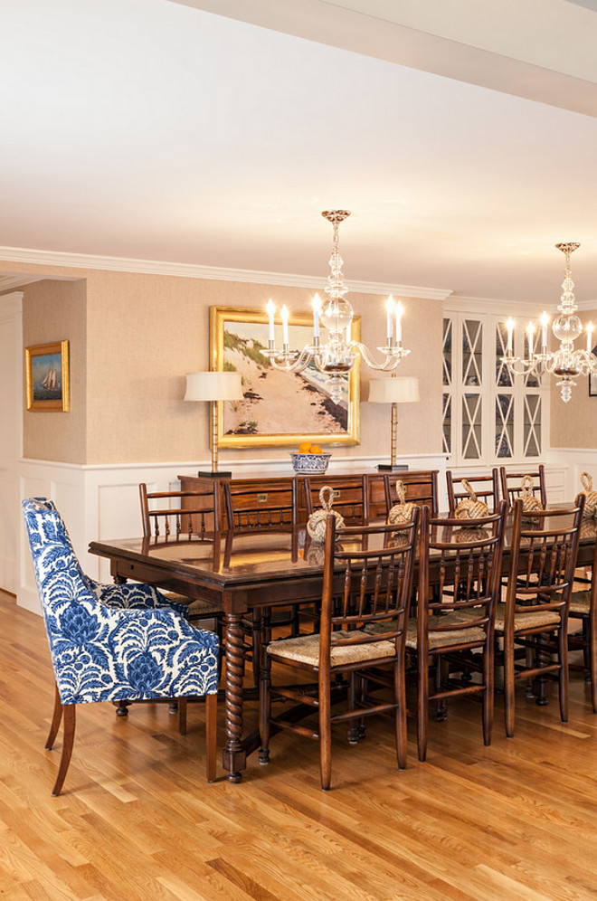 Traditional dining room with a twist. I love the traditional wainscoting, the wallpaper and the double chandeliers. The walls in the dining room are covered in grasscloth by Ralph Lauren. The chandeliers are from Visual Comfort and are even prettier in person. The fabric on the host and hostess chairs is Brunschwig & Fils Bromelia Resist in Blue. The Marcy Armchair is from Kravet and can be ordered in any fabric. Table is custom from Kravet and side chairs are from a consignment shop. #diningroom #traditionalDiningroom #diningroom #chandeliers #furniture Violandi + Warner Interiors