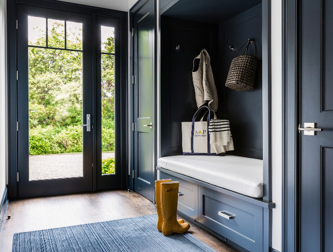 Dark Blue Mudroom. Dark blue mudroom features a dark blue built in bench fitted with drawers placed under a dark blue backsplash lined with hooks flanked by dark blue closet doors. #Mudroom #darkblue #navy Alisberg Parker