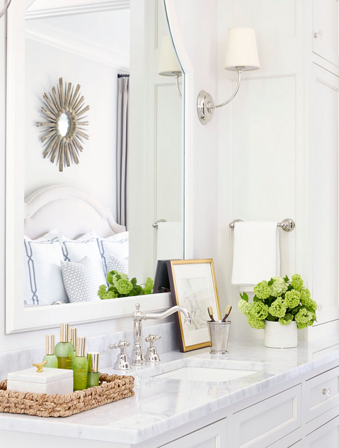 Bathroom countertop tray. A white and gray bathroom features separate washstands topped with polished marble fitted with square curved sinks and vintage hook and spout faucets placed under white arched mirrors illuminated by Vendome Single Sconces. A white marble tiles frame marble basketweave tiles accented with gray border tiles lead to a white rope stool topped with a fern plant placed under a window dressed in white and gray cafe curtains. Sarah Bartholomew Design