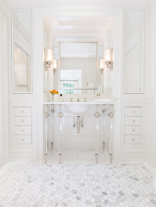 Bathroom washstand. Bathroom washstand. Bathroom features a 6 leg nickel and glass washstand topped with marble placed under a satin nickel mirror flanked by floor to ceiling built in cabinets accented with mirrored cabinet doors alongside a marble hexagon tile floor. #Bathroomwashstand #bathroom #washstand Sarah Bartholomew Design