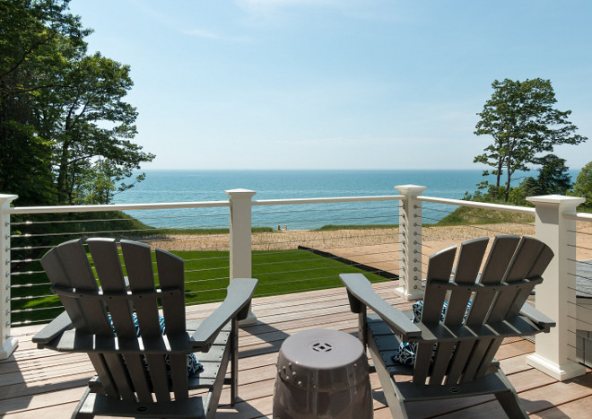 Deck Cable Rail. Outdoor Railing, balusters and newels. Hand railing and newels are composite wood painted in Benjamin Moore Dune White. Balusters are stainless cable rail.