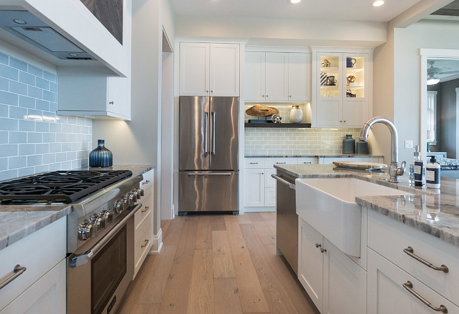 Kitchen with light blue backsplash tile. Pale blue subway tile forms a serene backdrop to rift-cut oak cabinetry and fantasy blue granite countertops in the light and airy kitchen. Tiles are Walker Zanger 6th Ave in Pale Sky; Gloss 3 x 6.