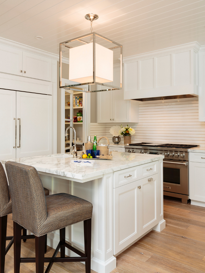 Kitchen. White kitchen. Fresh new white kitchen with island and light hardwood flooring. An intriguing backsplash tile resembles shiplap wainscoting. #kitchen #whitekitchen #white #kitchen Designed by Barclay Butera