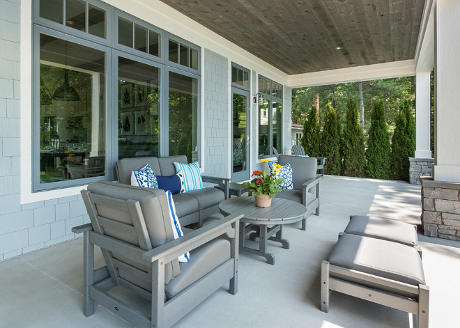 Porch with reclaimed pine barnwood ceiling, stone columns and shingle exterior.