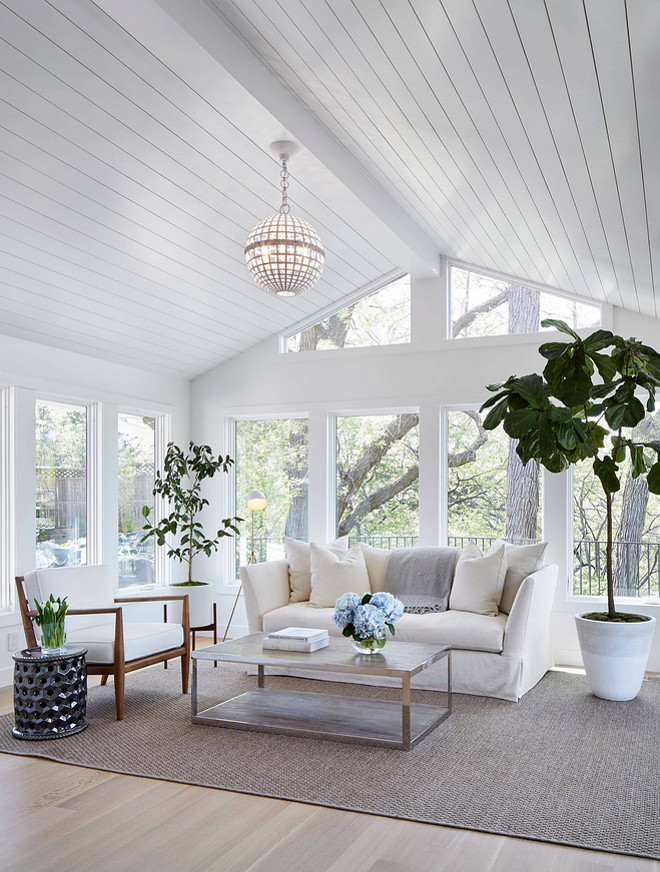 Shiplap ceiling. Living room with shiplap ceiling. Living room with wood paneled ceiling and floor-to-ceiling windows. Porch ceiling paint color is Benjamin Moore Super White in Satin Finish. Chair: Redford House Chair with Linen-like Acrylic fabric that is mildew, fade, soil, and stain resistant. Coffee Table: Dovetail Coffee Table in Stainless Steel Finish and Burnt Oak Table Top. Chandelier: Globe Ceiling Light - Visual Comfort ARN5002PW AERIN Mill Ceiling Light in Plaster White #shiplapceiling #shiplap #ceiling Martha O'Hara Interiors