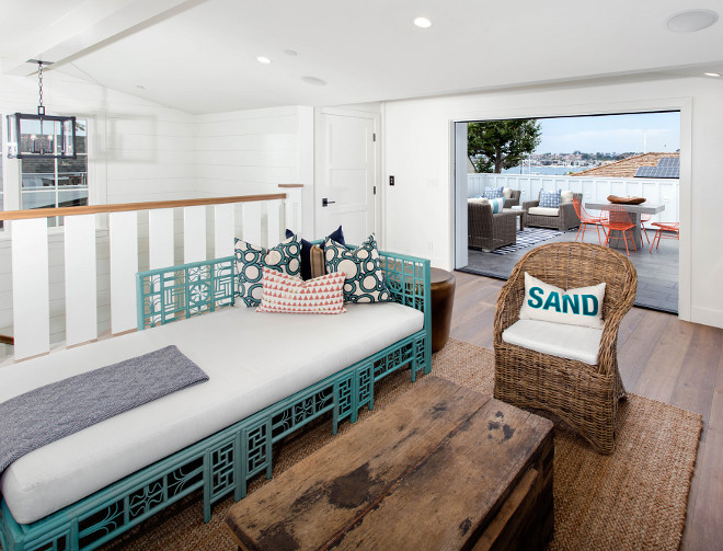 Coastal family room with reclaimed wood table, wicker chair, jute rug and turquoise daybed. Blackband Design