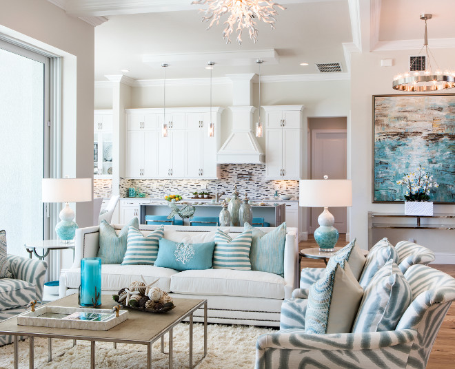 Grey interiors with white cabinets and turquoise decor Beautiful open floor plan home with white kitchen cabinets, grey walls and turquoise decor and accessories. #greywalls #openfloorplan #whitecabinet #turquoise #turquoisedecor Robb & Stucky