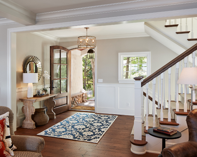 Foyer front door. Foyer wainscotting. The front door is custom, stained in Valspar Antique Mahogany. Wainscotting paint color is Benjamin Moore White Dove. #foyer #frontdoor #wainscotting #BenjaminMooreWhiteDove Vivid Interior Design. Hendel Homes