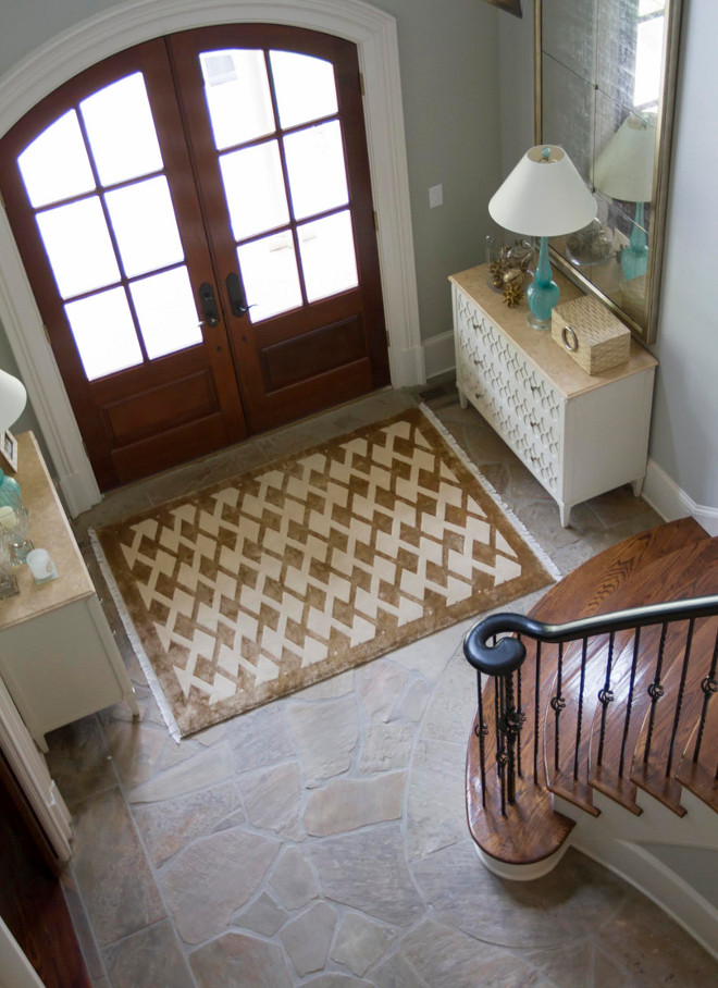 This foyer is tailored but welcoming at the same time. Using two consoles create a balanced symmetry in the space. Stair Risers and Baseboard Paint Color: Sherwin Williams Divine White. Handrail and Spindles: Benjamin Moore Black. Rug: Stark Tibetan Silk. Home Bunch Beautiful Homes of Instagram bluegraygal