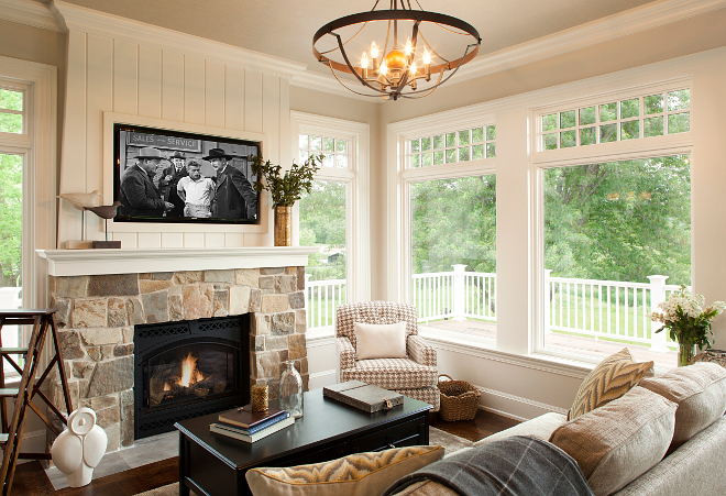 Family room. Isn't this room perfect to relax with a cup of coffee or to watch your favorite show? I love the shiplap above the fireplace mantel. Wall paint color is Benjamin Moore OC-15 Baby Fawn, the stone fireplace is a custom blend and ceiling features grasscloth wallpaper. Ceiling light is Murray Feiss. #familyroom Vivid Interior Design. Hendel Homes 
