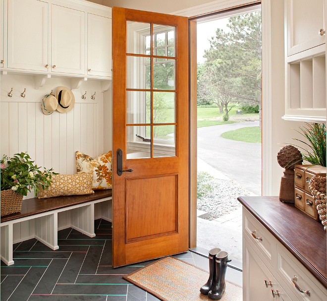 Mudroom. Who wouldn't love to have a mudroom like this?! Floors are Black Slate tile in a herringbone pattern. The wall color is Benjamin Moore Baby Fawn OC-15 and the cabinets are Benjamin Moore Icicle 2142-70. #mudroom #paintcolor #flooring #herringbone #tile #blackslate Vivid Interior Design. Hendel Homes