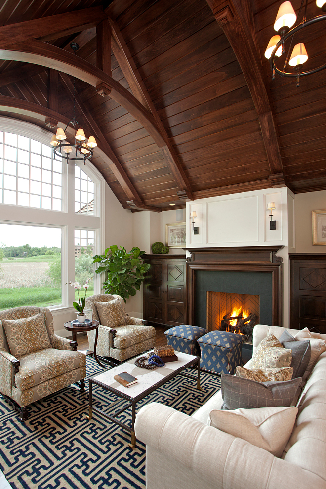 The focal point of this room is the breathtaking ceiling made of Poplar wood. Lighting is the Classic Ring Chandelier from Visual Comfort. Cabinets and mantle are Walnut in custom stain. poplar-tongue-and-groove-ceiling-in-custom-stain #livingroom #ceiling #woodceiling #poplar #ceilings Vivid Interior Design. Hendel Homes