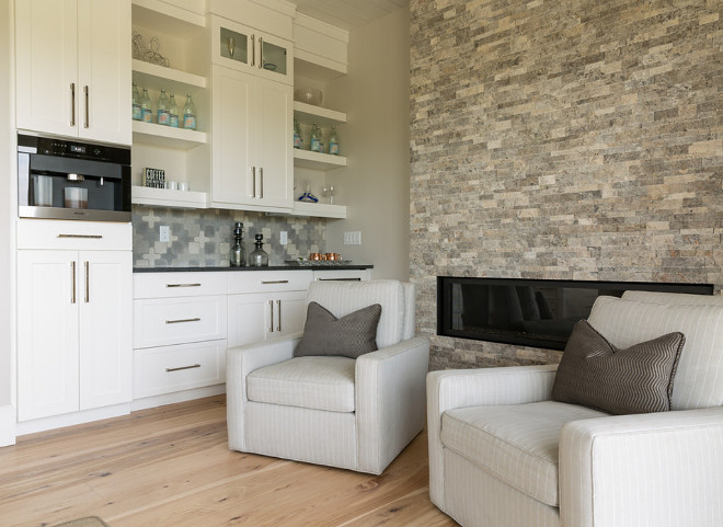 Wet Bar. Located just off the dining area, this wet bar features a modern stone fireplace swivel chairs and Hickory Chair swivel chairs with Pindler striped linen fabric. #wetbar wet-bar Restyle Design, LLC.