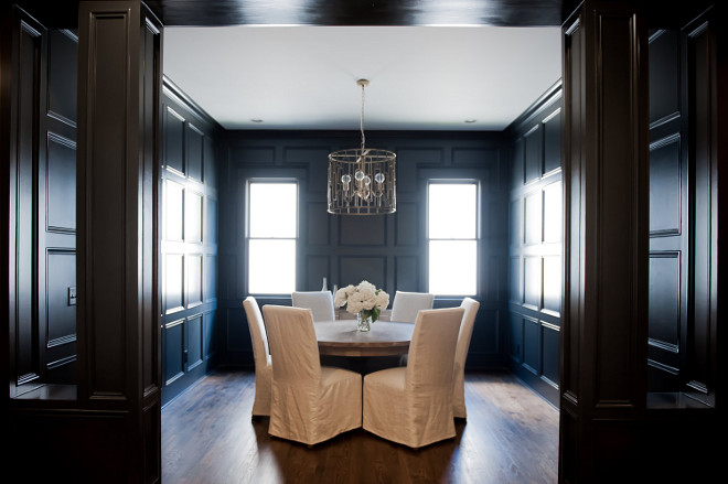 Dark stained paneled dining room with white slipcovered chairs and round dining table. dark-stained-paneled-dining-room-with-white-slipcovered-chairs-and-round-dining-table Redo Home and Design.