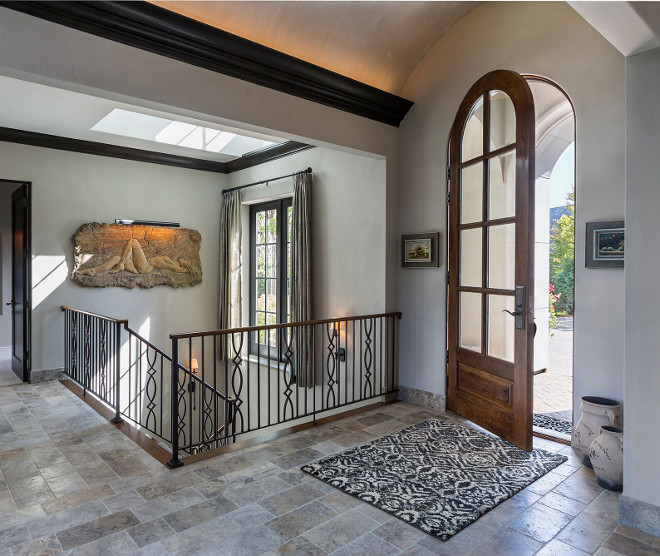 French foyer. The foyer features arched barrel ceiling, custom stairway railings and a skylight. Floor tile is Italian Limestone. #FrechFoyer #Foyer #BarrelCeiling #Limestonefloortile #limestone french-foyer Hendel Homes