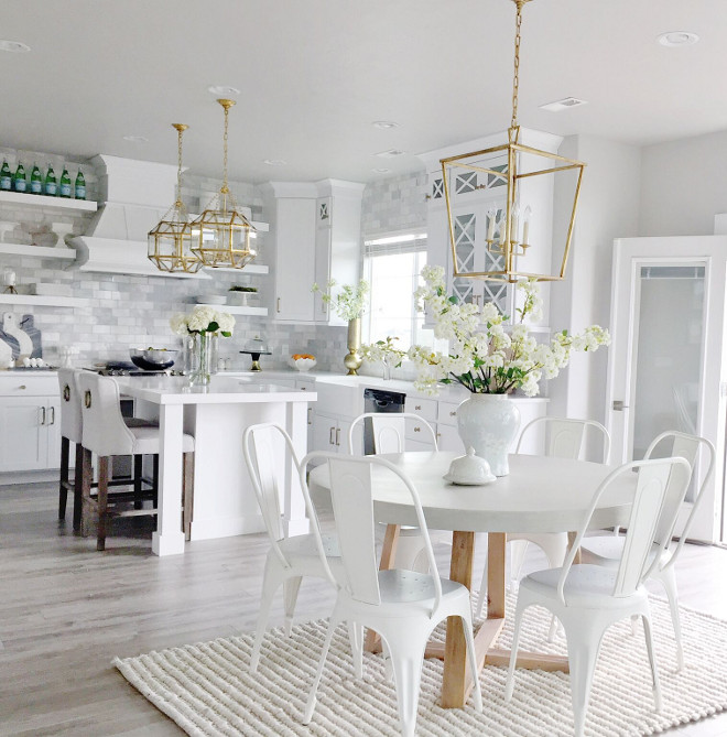 White Kitchen with open breakfast room. Beuatiful White Kitchen with open breakfast room with brass lighting, Darlana Lantern, crisp white Tolix chairs and kitchen with white quartz countertop and marble subway tile. #kitchen #whitekitchen #openkitchen #breakfastroom #whitecountertop #marbletile #marblesubwaytile #tolix #chairs Home Bunch's Beautiful Homes of Instagram janscarpino