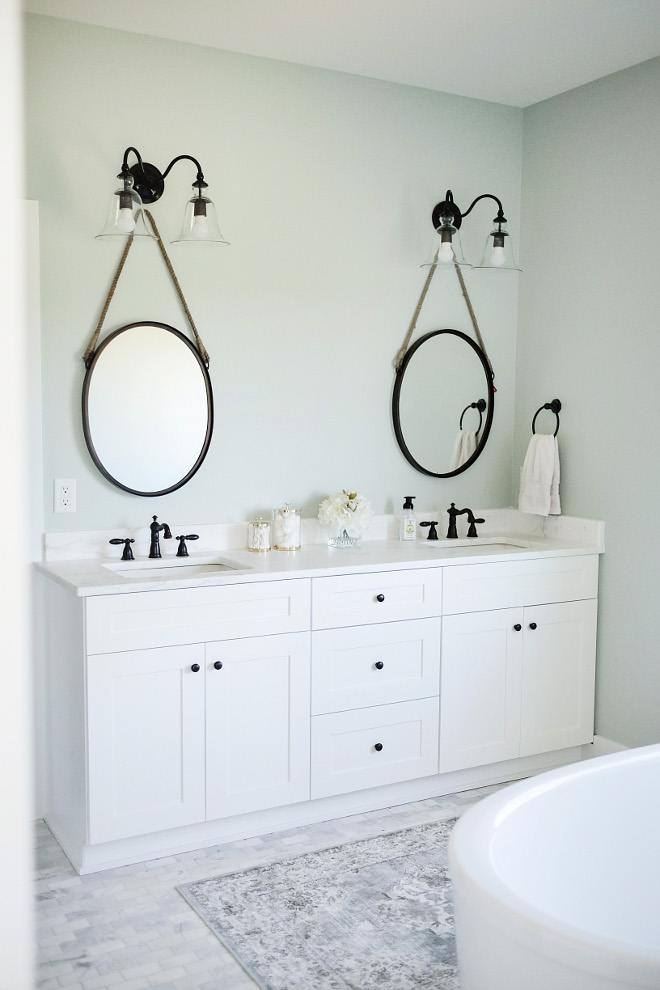 Master bath. Farmhouse master bath. Farmhouse bathroom. I like how this entire room feels calm but it still hold some strong elements. Rug is from HomeGoods and the floor tile is "The Tile Shop". Mirrors: World Market. Gold Bath Accessories: Target. Light Fixture: Pottery Barn's Rustic Glass Double Sconce. #farmhouse #masterbath #bathroom #farmhousebathroom Beautiful Homes of Instagram @nc_homedesign via Home Bunch