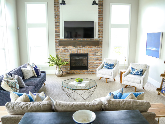 This farmhouse-inspired fireplace features brick, shiplap and barn lighting. The brick on fireplace is Old Irvington Brick- Flush cut, over-grout, natural gray mortar. Fireplace barn sconces are Raliegh 11" Wall Lantern from Savoy House Millhaven Homes