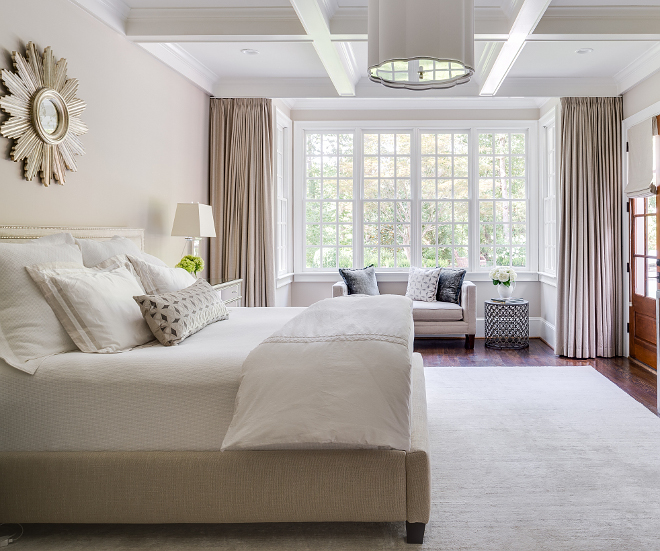 Neutral bedroom design, furniture and decor list. Draperies are custom by Home Accents. The designer chose a Square Feather bench for the alcove for looking out onto the backyard. Pillows by Square Feathers as well. The bed is a Mitchell Gold bed covered in a natural linen with Anne Selke bedding. Light fixture by Circa Lighting. Bedside tables and Starburst mirror are from Worlds Away and the lamps are from RH. #neutralbedroom #bedroom #furniturelist #decorlist neutral-bedroom Interiors by Courtney Dickey. Architecture by T.S. Adam Studio.