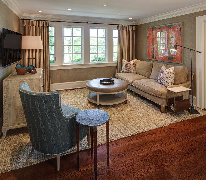 Family Room. This cozy family room is the perfect place to relax and watch your favorite shows. Don't you love this neutral color palette? Sofa: Custom chenille sofa with wheat colored tape and burnished brass nailheads. Blue Chair: Hickory Chair's winged chair with Mark Alexander diamond weave patterned fabric. Ottoman: Vanguard pewter leather ottoman. Rug: Surya ivory wool rug. Chest: CFC gray wash wax chest. Art: Orange embroidered artwork in acrylic glass frame. Pillows: Pillow fabric is Lee Jofa Shaftesbury. #Familyroom W Design