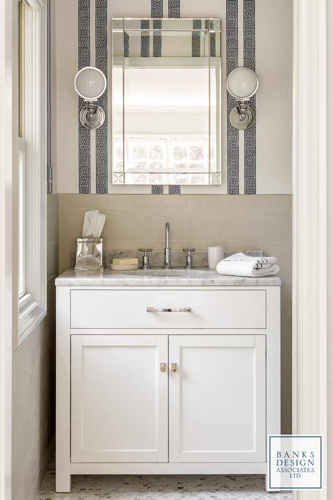 Small Bathroom. The homeowner and designer decided that every bedroom in the house would have its own bathroom, no matter how small it might be. This bathroom features a Greek-key wallpaper and a marble topped vanity painted in Benjamin Moore Decorator's White. Wall covering is Schumacher & Co. Greek Key Stripe in Navy. #smallbathroom #smallinteriors #bathroom #smallbathrooms Banks Design Associates, LTD & Simply Home