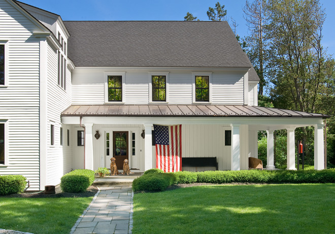 White Farmhouse. White Farmhouse with American Flag on Porch. White Farmhouse. #WhiteFarmhouse #AmericanFlag #Porch #frontporch White Farmhouse white-farmhouse Banks Design Associates, LTD & Simply Home