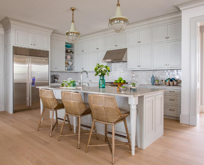 Benjamin Moore Gray Owl Kitchen with Quartzite Countertop. Well-designed kitchens are well laid out for maximum efficiency and flow. They should also feel inviting and have plenty of functional storage. A coastal feel can be found in this kitchen through the choices of color, cabinetry door style, finishes and lighting. Lighting is Malplaquet from Urban Electric. Floors are a white oak with a custom gray stain. #kitchen