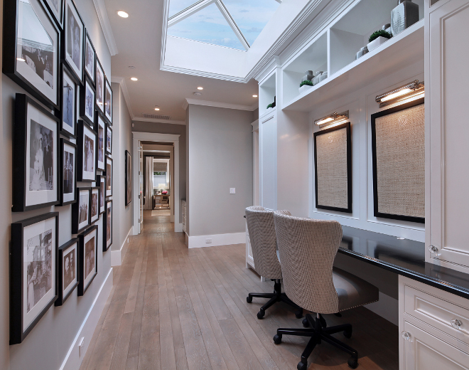 Hall Home Office Built in Desk. This hall connects the main living areas to the bedrooms. A skylight brings plenty of natural light to this side of the house. Home Office. Galley wall. Pictures on wall. Gallery wall ideas. Hall gallery wall. Built in desk, skylight. Hall Home Office #HomeOffice Brandon Architects, Inc