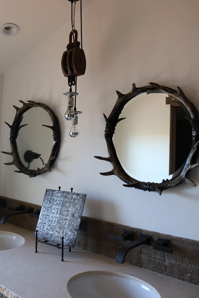 Rustic Bathroom. A floating vanity made from distressed wood and stone keep this narrow space open and light. Rustic mirrors and and vintage lighting add a western industrial flair. Countertop is Torreon stone slab. Wall mounted faucets are Ferguson. Rustic Bathroom #RusticBathroom Home Bunch's Beautiful Homes of Instagram @birdie_farm